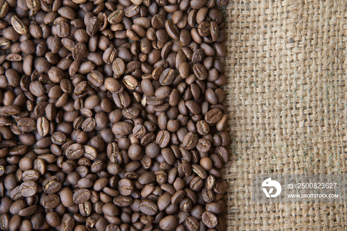 coffee beans background on sack cloth.Texture with copy space of roasted coffee beans on gunny bag