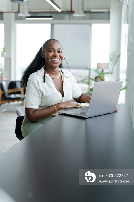 Businesswoman with laptop working in modern office