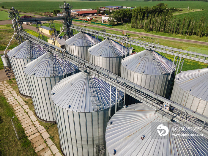 Aerial view over agricultural grain silos. Cereal plants crop storage tanks