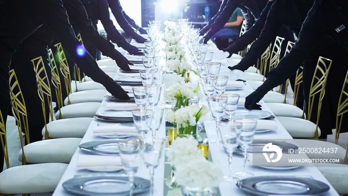 Large group of waiters serving a banquet.