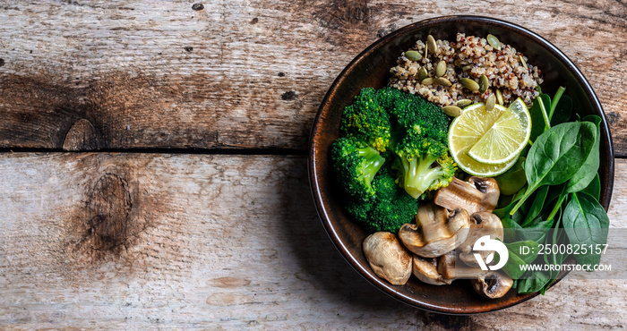 Diet salad made from fresh vegetables broccoli, mushrooms, spinach and quinoa in a bowl. Delicious breakfast or snack, Clean eating, dieting, vegan food concept. Long banner format. top view