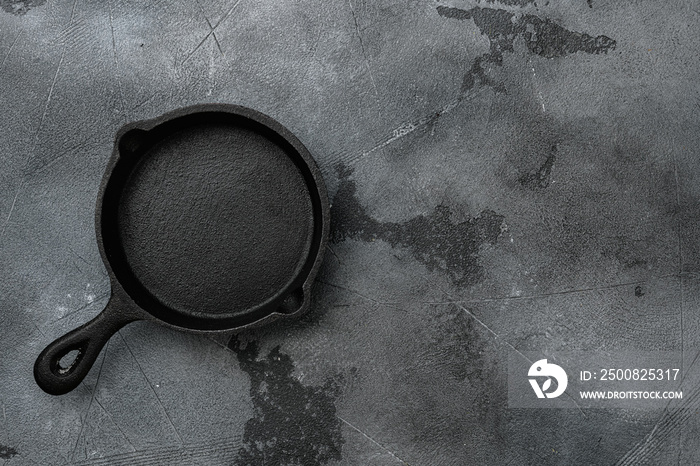 Empty cast iron skillet with copy space for text or food with copy space for text or food, top view flat lay , on gray stone table background