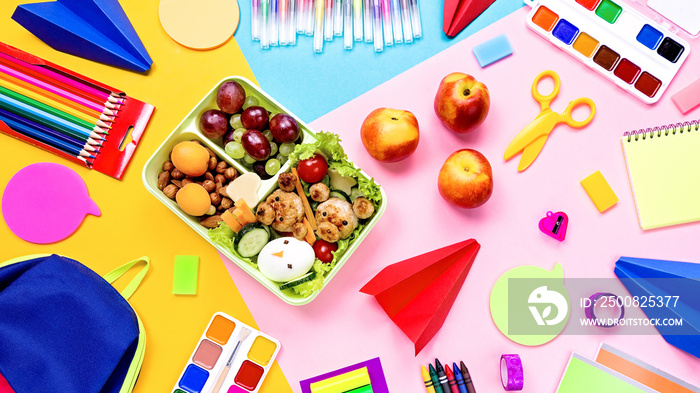 School supplies and lunchbox with food for kids. Colorful stationery layout on multicolor background, copy space