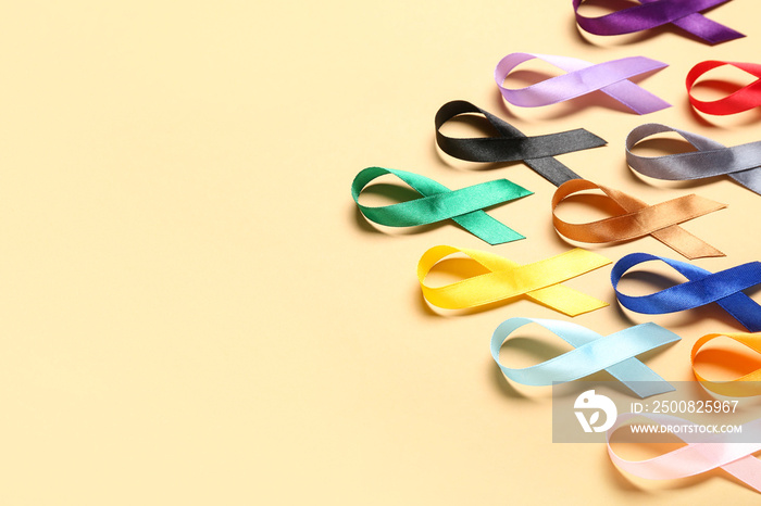 Colorful awareness ribbons on beige background. World Cancer Day concept