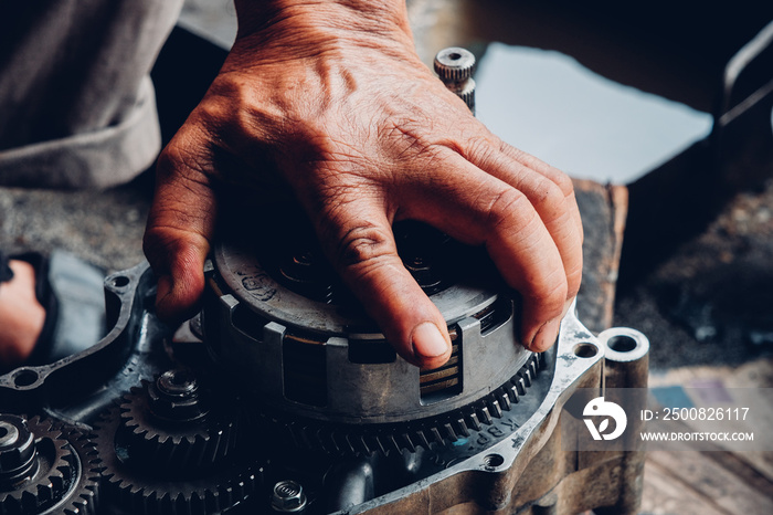 Maintenance of motorcycle engine clutch system by a technician.