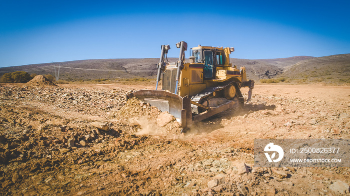 Aerial image of a bulldozer pushing and ripping ground on an agricultural piece of land