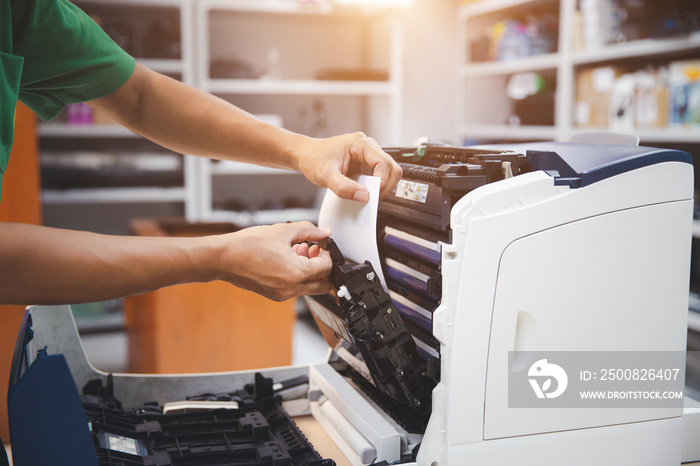 Technician hand open cover photocopier or photocopy to fix repair copier paper jam and replace ink cartridges for scanning fax or copy document in office workplace.