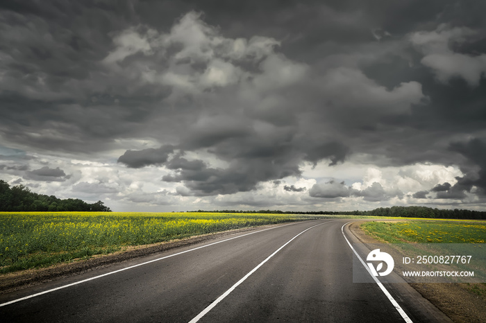 Summer country road before thunder storm. Dramatic sky.