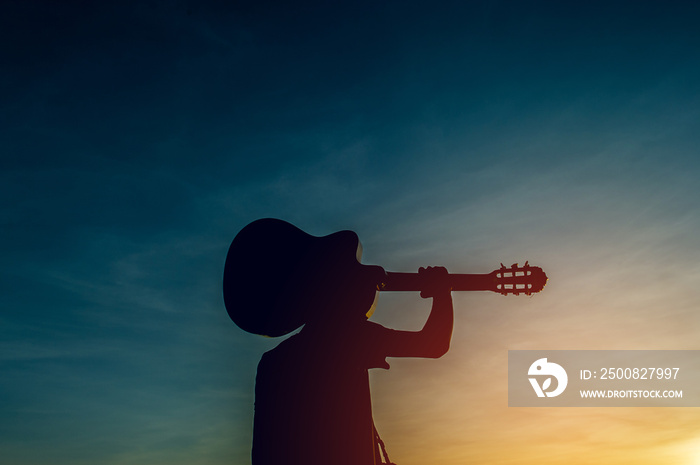 Silhouette of a guitarist in the shadows at sunset light, silhouette concept.