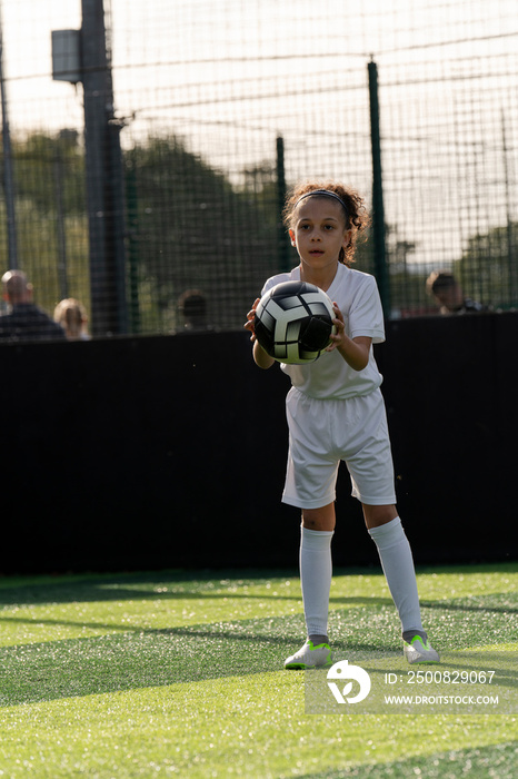 Girl (6-7) playing soccer on soccer field