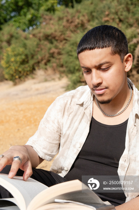 Man reading book on beach