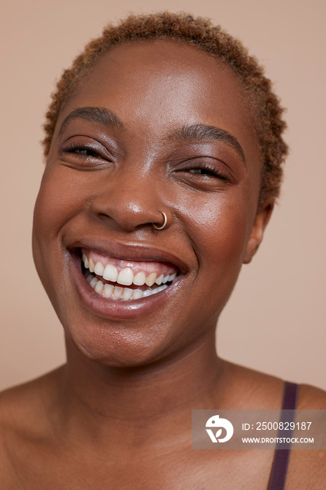 Studio portrait of smiling woman with nose ring