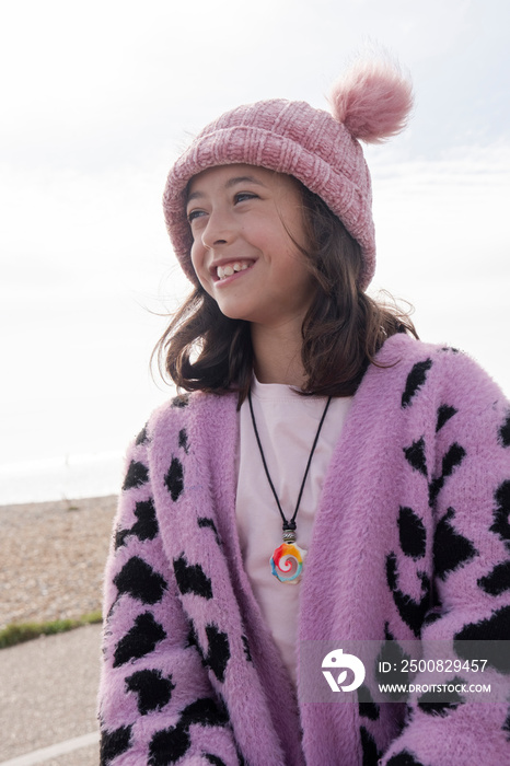 Portrait of smiling girl on beach on cloudy day