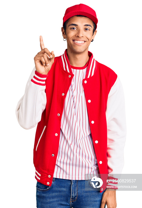 Young african amercian man wearing baseball uniform showing and pointing up with finger number one while smiling confident and happy.