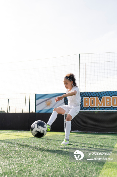 Girl (6-7) playing soccer on soccer field