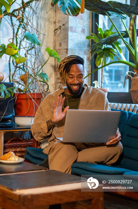 Man sitting on sofa and using laptop