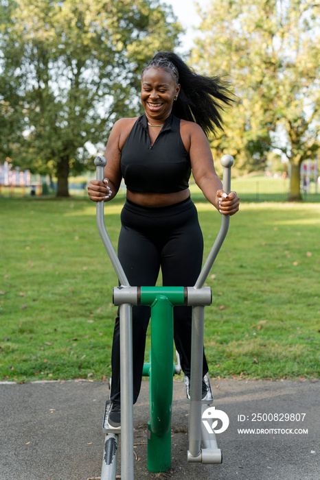 Smiling young woman exercising in outdoor gym