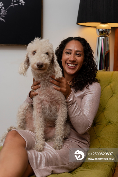 Woman sitting with bedlington terrier on her lap