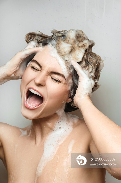 Young beautiful woman singing and washing her hair with shampoo