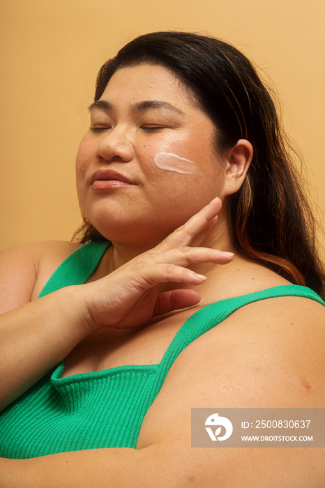 Plus size Asian female solo lifestyle studio portrait skin care shot