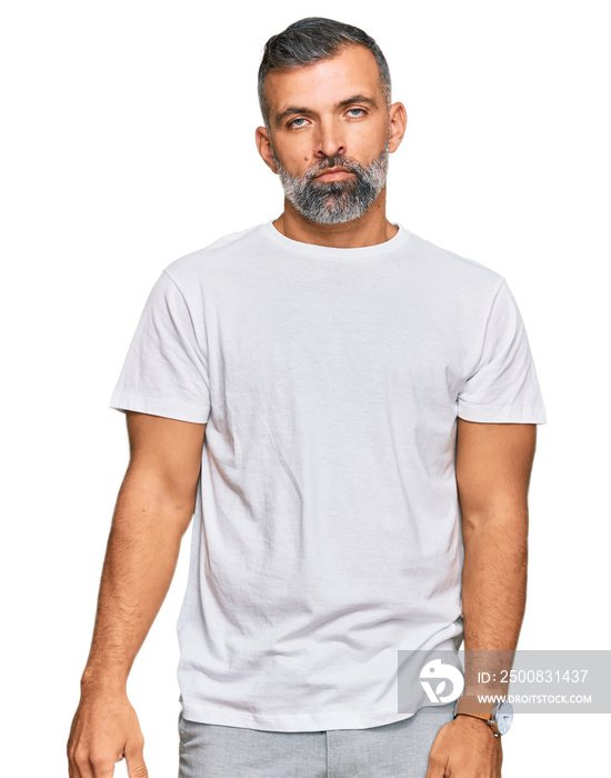 Middle age handsome man wearing casual white tshirt looking sleepy and tired, exhausted for fatigue and hangover, lazy eyes in the morning.