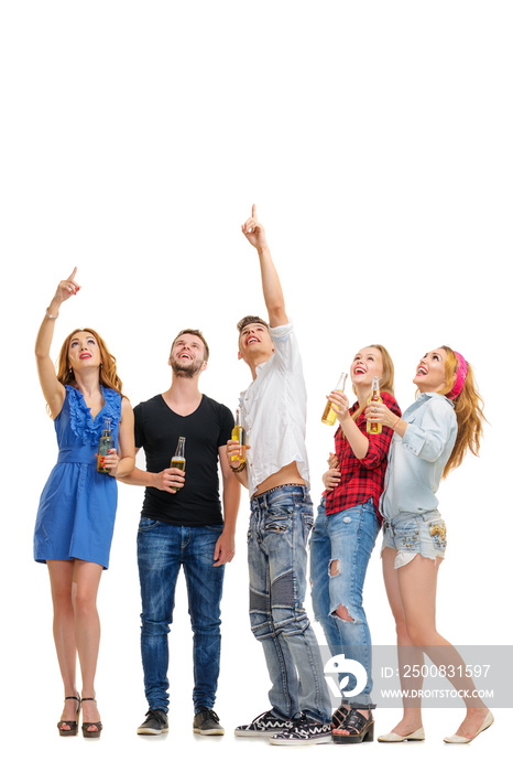 Your tex here. Party and relax. Group of amazed friends with bottles of beer looking up and pointing copy space. Isolated on white.