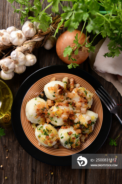 Meat stuffed potato dumplings with fried onion  and greaves on top