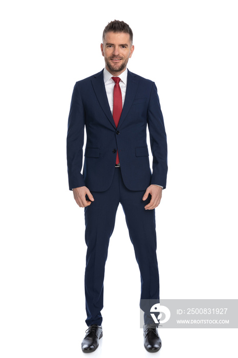 elegant guy dressed with a navy suit with red tie