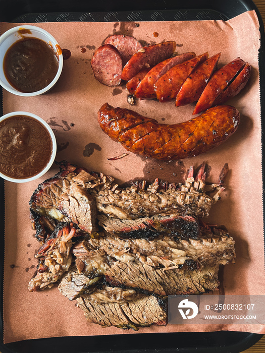 Big steak brisket with barbecue sauce and sausages.