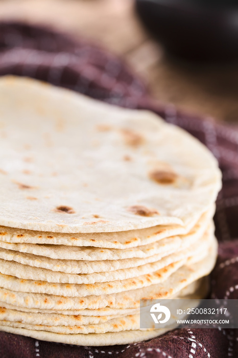 Fresh homemade flour tortillas on kitchen towel (Selective Focus, Focus on the front of the tortillas)