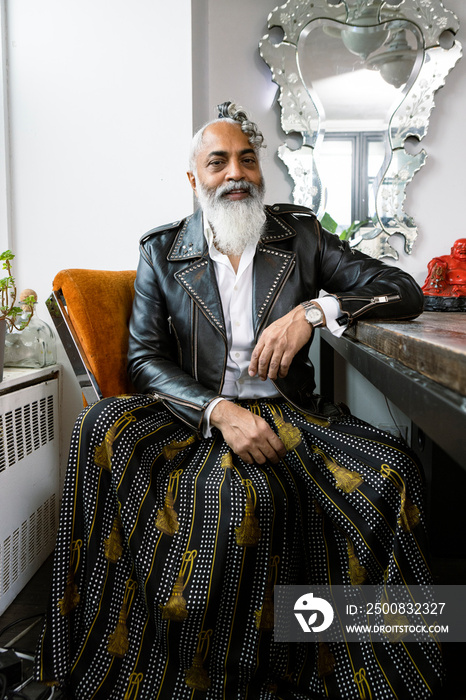 portrait of man with gray beard wearing leather jacket and skirt