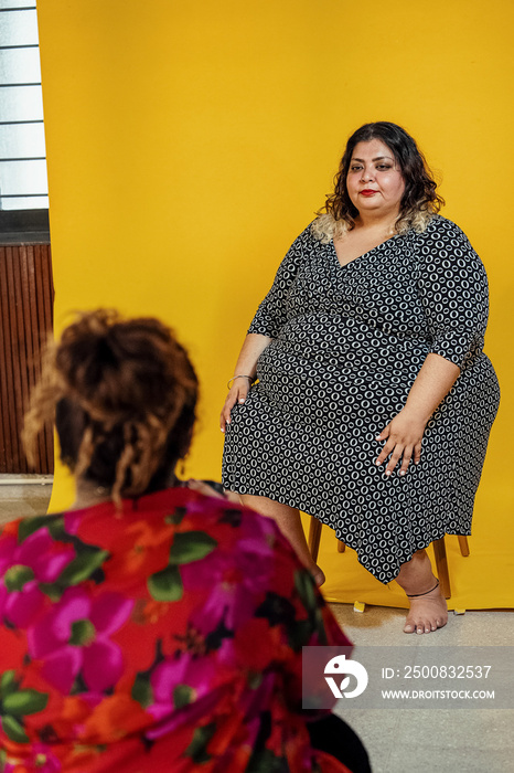 Plus sized female getting her headshots taken by a south asian female photographer