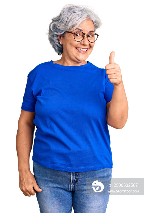 Senior woman with gray hair wearing casual clothes and glasses smiling happy and positive, thumb up doing excellent and approval sign