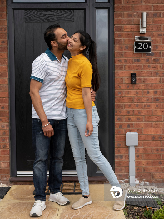 Couple kissing on front porch