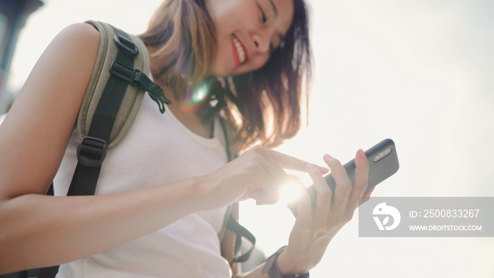 Cheerful Asian backpacker blogger woman using smartphone for direction and looking on location map while traveling at Chinatown in Beijing, China. Lifestyle backpack tourist travel holiday concept.