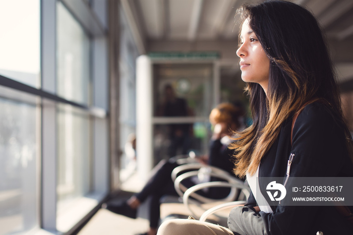 Young woman waiting for plane at airport lounge