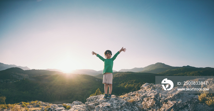 A boy on top of a mountain.