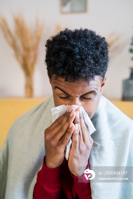 African American boy with cold and wiping his nose