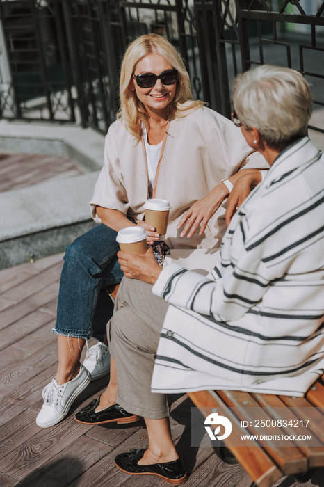 Smiling woman holding a paper cup of coffee