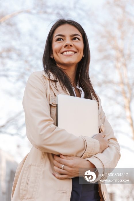 Smiling young woman dressed in autumn coat