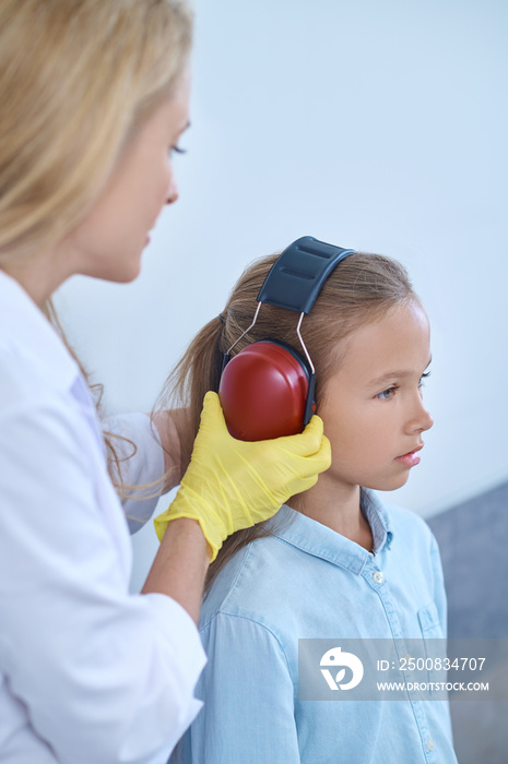 Girl being prepared for a hearing test by a medical professional