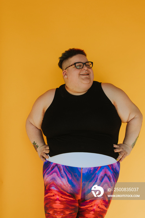 portrait of a plus size woman on yellow backdrop