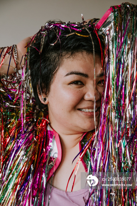 portrait of a plus size filipino woman looking at camera wearing a tinsel jacket