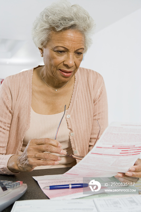 An African American senior woman reading domestic financial bill