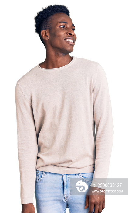 Young african american man wearing casual clothes looking away to side with smile on face, natural expression. laughing confident.