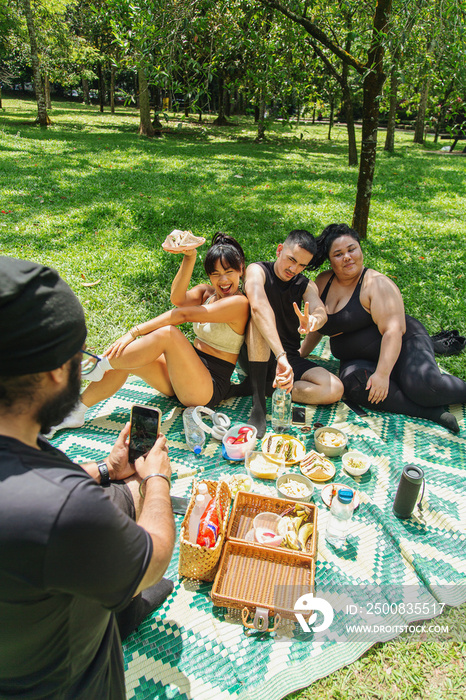 Group of friends having a picnic together at the park