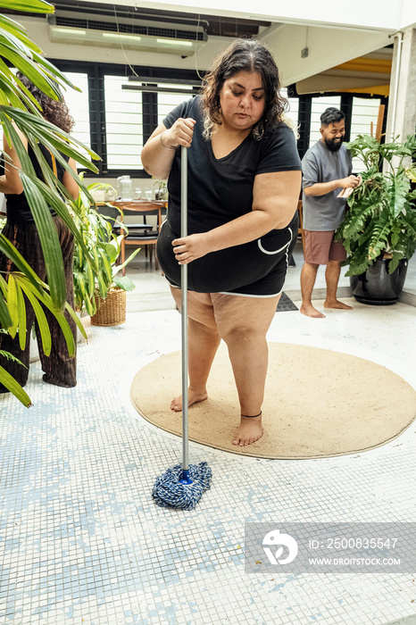 Group of housemates cleaning their home together