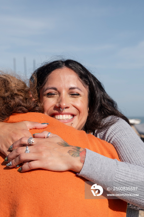 Mother and daughter embracing on sunny day