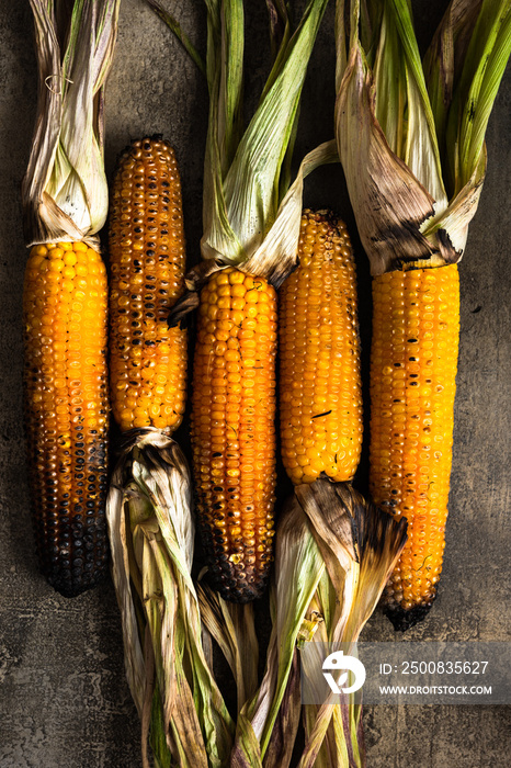 Roasted corn cobs on stone table, grilled organic food