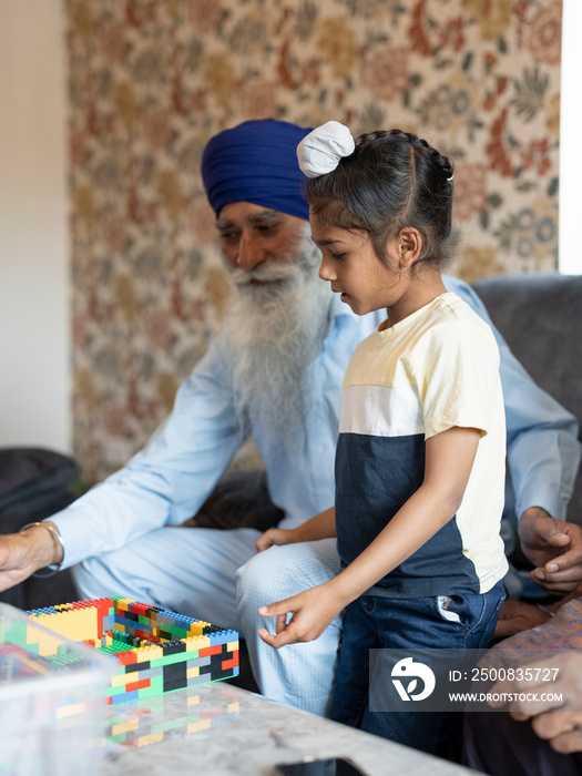 Grandfather and grandson (6-7) playing with toy blocks